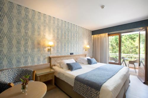 a hotel room with a bed and a table and a couch at Negroponte Resort Eretria in Eretria