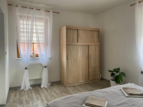 1 dormitorio con 1 cama y armario de madera en Apartmán Šimon en Cheb