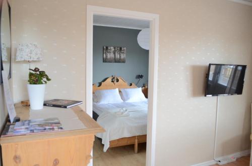 a bedroom with a bed and a desk with a television at Hazel Ridge in Hudiksvall