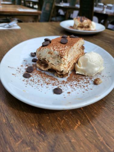 a white plate with a piece of cake and ice cream at Arnos Manor Hotel in Bristol