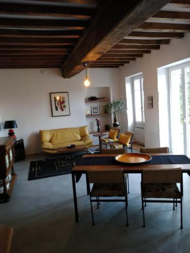 sala de estar con sofá amarillo y mesas en Maison Haute en Moux-en-Morvan