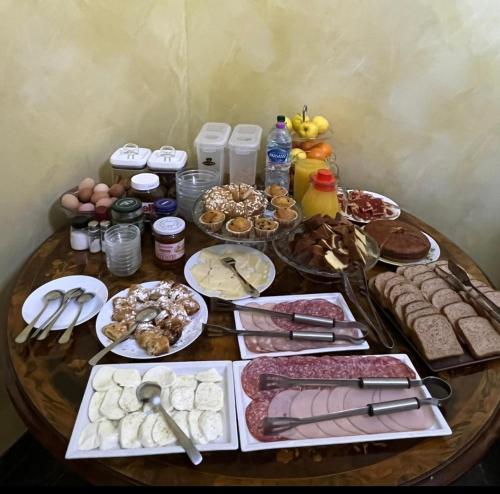 einen Holztisch mit einem Tisch voller Essen drauf in der Unterkunft B&B Roma Royal Residence in Rom