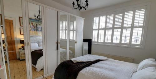 a bedroom with a bed and a mirror at Cosy, dog friendly house on the fringe of the Brecon Beacons in Tredegar