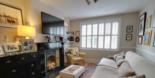 a living room with a couch and a fireplace at Cosy, dog friendly house on the fringe of the Brecon Beacons in Tredegar