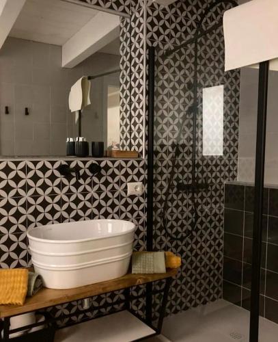 a bathroom with a white tub and a black and white tiles at A 20 Passi... in Rocca Imperiale