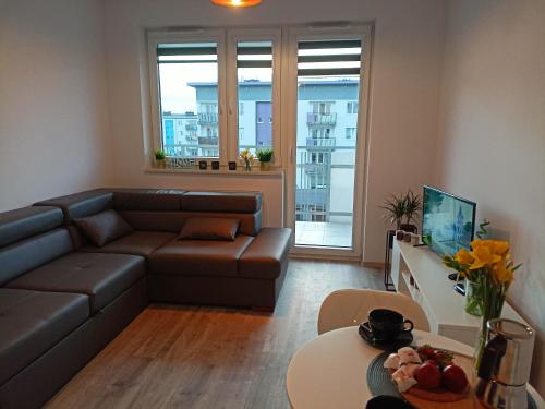 una sala de estar con un sofá y una mesa en Apartament z Sauna i Jacuzzi, en Radom