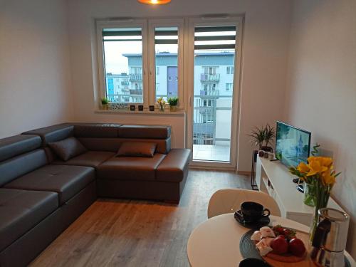 een woonkamer met een bank en een tafel bij Apartament z Sauna i Jacuzzi in Radom