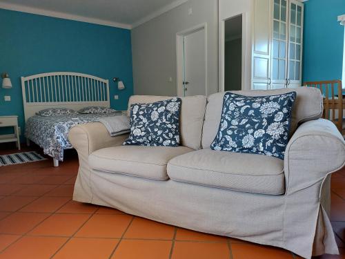 a couch with two pillows on it in a living room at MirArte in Montemor-o-Novo