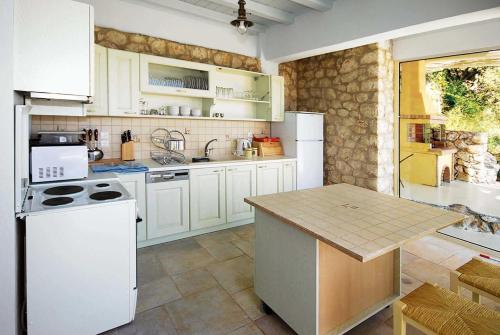 a kitchen with white appliances and a table in it at Anemus in Sivota