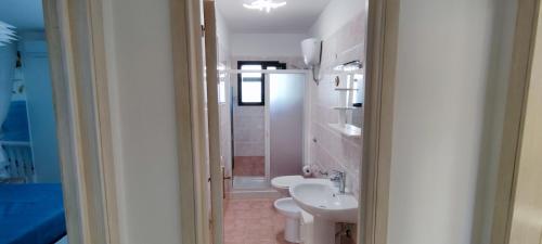 a bathroom with a white toilet and a sink at Emily House in Porto Cesareo