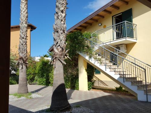 two palm trees in front of a building with a staircase at Villa Gabriella in Patti