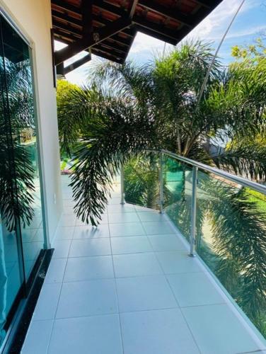 a balcony of a house with palm trees on it at Alter do Chão Casa de praia nobre beira mar in Alter do Chao