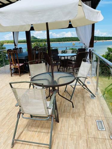 a table and chairs and an umbrella on a deck at Alter do Chão Casa de praia nobre beira mar in Alter do Chao