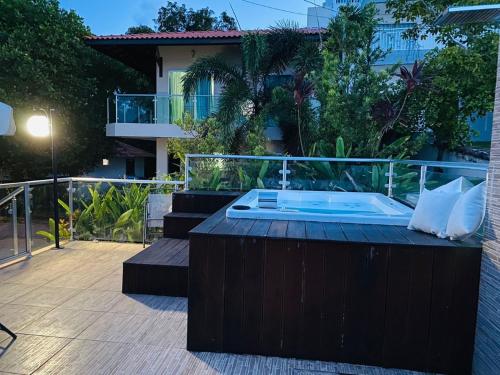 a hot tub on a deck with a house at Alter do Chão Casa de praia nobre beira mar in Alter do Chao
