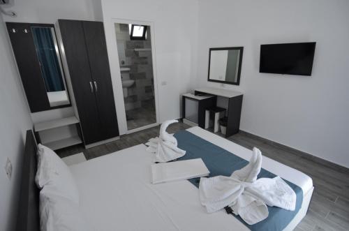 a bedroom with a bed with white sheets and a mirror at Vila 69 in Costinesti