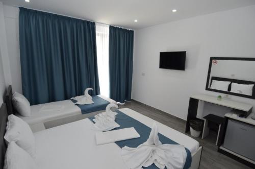 a hotel room with two beds and a television at Vila 69 in Costinesti