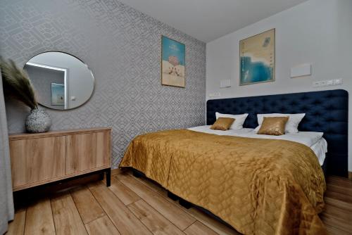a bedroom with a large bed and a mirror at Aparthotel Anchoria BlueApart in Mechelinki