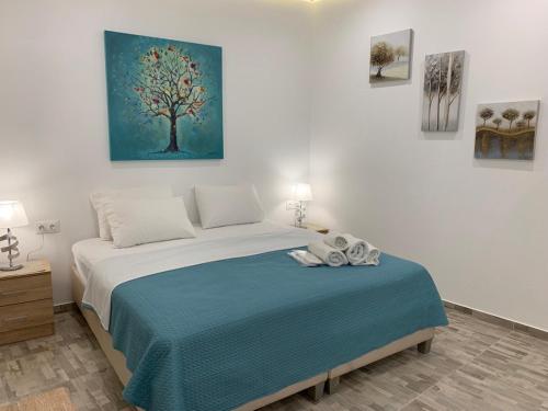 アテネにあるSantorini studio for 2 person in Athens near sea& centerのベッドルーム1室(木の絵画が壁に描かれたベッド1台付)