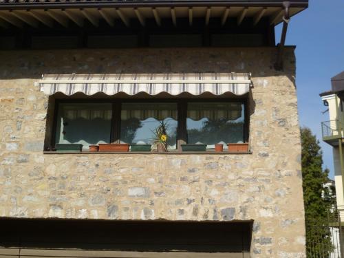 a window with a sunflower in the middle at Nido del Tadini in Lovere
