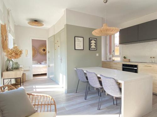 une cuisine avec une grande table blanche et des chaises dans l'établissement La Terrasse sur les Toits, à Narbonne