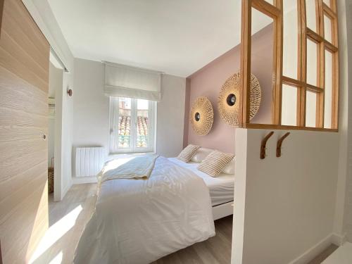 a bedroom with a bed and a window at La Terrasse sur les Toits in Narbonne