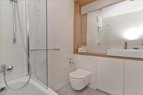 a bathroom with a shower and a toilet and a sink at Aparthotel Anchoria BlueApart in Mechelinki
