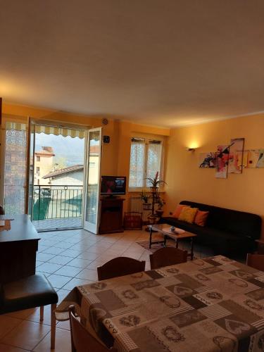 a living room with a table and a couch at Casa Amarela in Gravedona