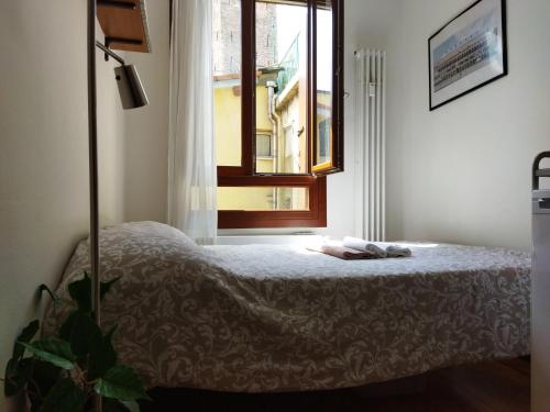 um quarto com uma cama e uma janela em La Torre Monolocale em Pádua
