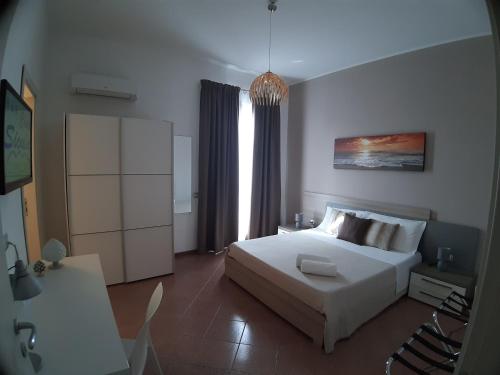 a bedroom with a large white bed and a window at B&B Costa Sicula in Avola