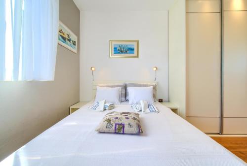 ein Schlafzimmer mit einem weißen Bett mit zwei Kissen in der Unterkunft Studio Apartment Vesna in Krk