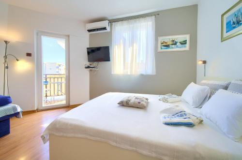 ein Schlafzimmer mit einem großen weißen Bett mit Handtüchern darauf in der Unterkunft Studio Apartment Vesna in Krk