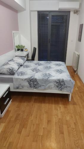 a bedroom with a large bed and a wooden floor at Exclusive Skopje Apartments in Skopje