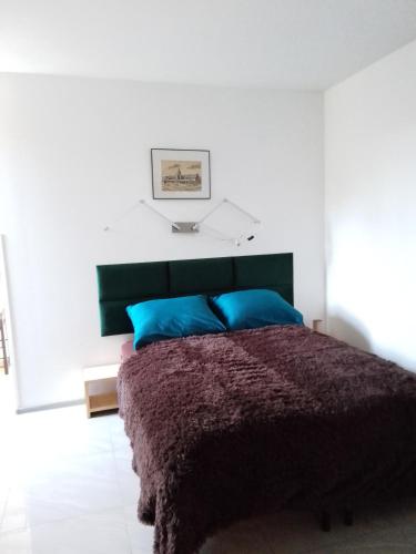 a bedroom with a large bed with blue pillows at Willa Gracja in Wisła