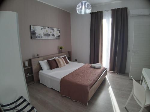 a bedroom with a large bed and a window at B&B Costa Sicula in Avola