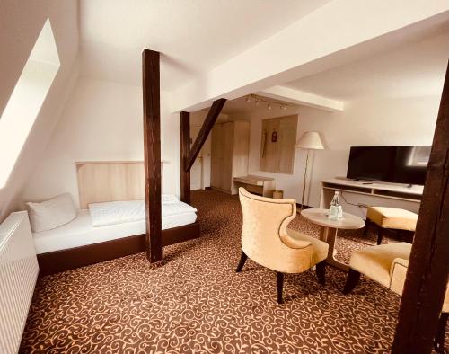 a hotel room with a bed and a couch and a table at Villa Antonia in Bautzen