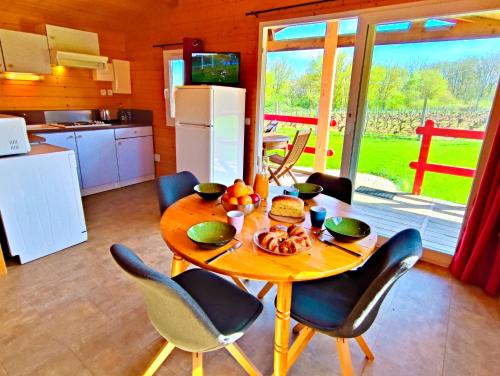 a kitchen with a table and chairs and a kitchen with a table and a table at LES CHALETS DE SANCERRE in Thauvenay