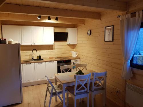 a kitchen with a table and chairs and a refrigerator at Chata Rafusa pod Śnieżnikiem in Stronie Śląskie