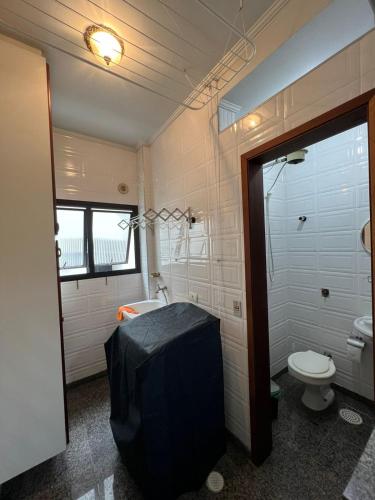 a bathroom with a tub and a toilet and a sink at Apartamento no Guarujá Enseada a beira mar, ótima localidade e com ar condicionado in Guarujá