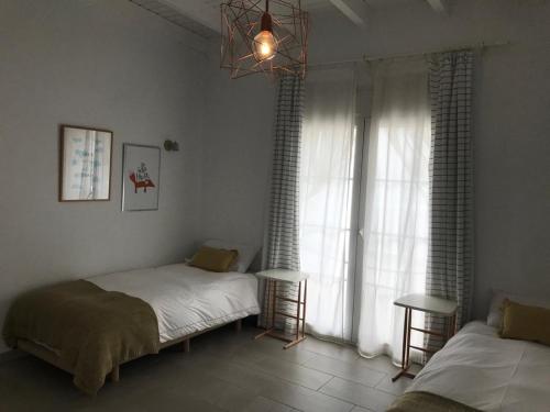 a bedroom with two beds and a large window at Chipibeach B&B, Hostal Boutique in Chipiona