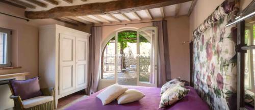 a bedroom with a purple bed and a window at Luxury Villa Among Vineyards in Arezzo