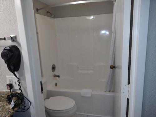 a bathroom with a toilet and a bath tub at Days Inn by Wyndham Port Charlotte Town Center in Port Charlotte