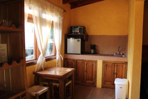 a kitchen with a refrigerator and a table and a window at Betos Departamentos in Valle de Bravo