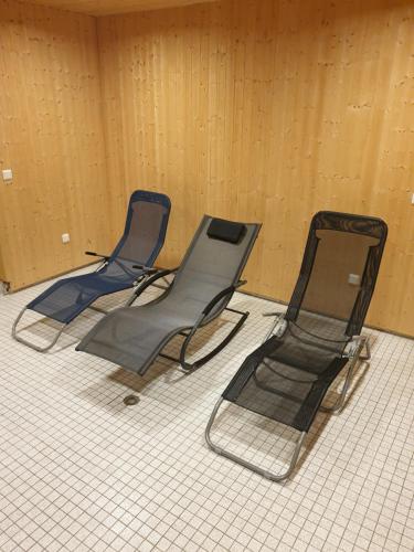 3 sillas sentadas en un suelo de baldosa en una habitación en Cityapartments MH, en Mülheim an der Ruhr