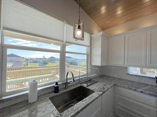 a kitchen with a sink and a large window at Crystal Blue home in Crystal Beach