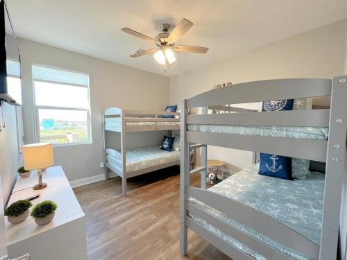 a bedroom with two bunk beds and a ceiling fan at Crystal Blue home in Crystal Beach