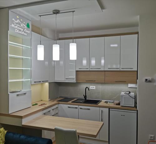 a kitchen with white cabinets and a sink at Melany Lux - Titova vila, Zlatibor in Palisad