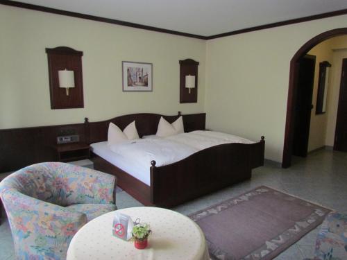 - une chambre avec un lit, une chaise et une table dans l'établissement Hotel Zum Erker, à Trebur