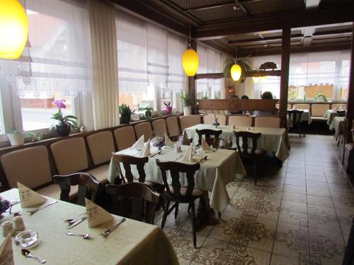 ein Restaurant mit Tischen und Stühlen in einem Zimmer in der Unterkunft Hotel Zum Erker in Trebur