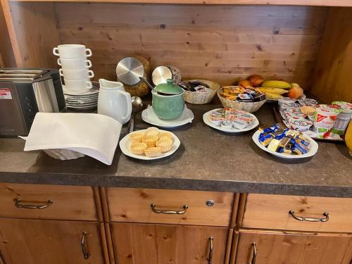 a kitchen counter with plates and bowls of food at Lindenhof Hetzenbach in Zell