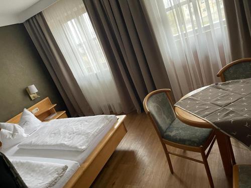 a bedroom with a bed and a chair and a table at Lindenhof Hetzenbach in Zell